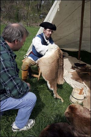 nbrn furtrade01p      4/26/2008  The Blade/Herral Long      Joe Mazur Carltom Michigan  looks at hides displayed by Ed Bundshuh of Ypsilanti mich     get photos of re-enactors in 1790s era clothing and visitors at the Fur Trade Day at the trading post. It will run from 10 a.m. to 4 p.m.  there will be demonstrations on scraping and pressing animal skins and re-enactors cooking period food over open wood fires.