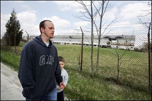 Shane Steele and his son, Mason, 5, walk around the former beryllium plant near Luckey that has been shuttered for decades.