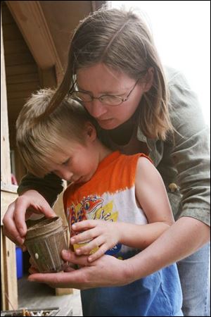 Slug: NBRW flowers23p     Date: 4/23/2008             The Blade/Amy E. Voigt       Location: Sylvania, Ohio  CAPTION:  Jeanette Sullivan helps her son Patrick, from Sylvania, plant seeds in a cup during 