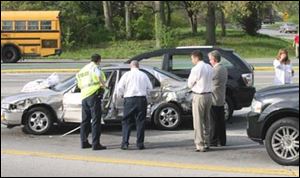 Authorities examine the crash site at Garden Road and Perrysburg-Holland Road in South Toledo.