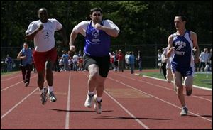 Erie County's Aaron Reed, Lucas County's Jimmy Jackson, and Wood County's Daniel Bowen compete in the 100-meter run. Elizabeth Case, 15, of Toledo tosses her way to first place in the Special Olympics softball throw during the Jennifer Adams Spring Games at the University of Toledo.