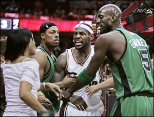 LeBron James yells at his mother, Gloria, to sit down after he
gets tangled up with Paul Pierce, left. Kevin Garnett helps out.
