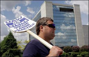 Machinist Scott Herzog pickets outside the American Axle headquarters in Detroit. Striking workers are to receive details of a proposed settlement beginning today.