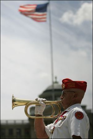 Larry J. Barnett of Temperance, Mich., who served in the U.S. Marine Corps, plays 'Taps' during the unveiling ceremony.