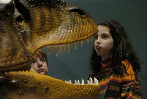 Visitors marvel at a reconstructed skull of an Allosaurus dinosaur at the University of Michigan Exhibit Museum of Natural History in Ann Arbor. 