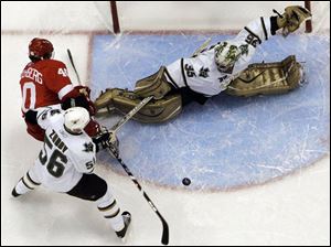 Dallas goalie Marty Turco sprawls for one of his 38 saves on Detroit's Henrik Zetterberg, left, as Sergei Zubov watches.