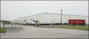 Truck-borne shipping containers await handling at a warehouse on Benore Road in Toledo. Such containers have become the backbone of global trade.