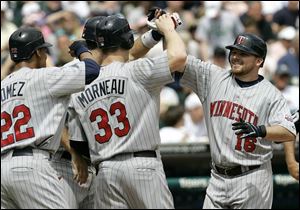 Minnesota's Jason Kubel, right, celebrates his grand slam against Detroit with Carlos Gomez and Justin Morneau.