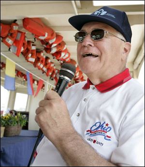 Local historian Fred Folger uses a microphone so those on the two-hour tour of the Maumee River can hear him provide a narration of Toledo s past.