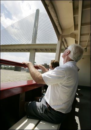 From a seat aboard the Sandpiper, Lee Kreuz, foreground, and his wife, Betty, background, both of them from Swanton, take a glimpse of the Veteran s Glass City Skyway, one of the bridges discussed during the river tour.