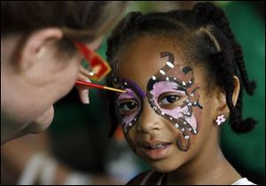 C'nece Chyanne Brown, 4, has her face painted by Chelsea Younkman during the Toledo Museum of Art's Juneteenth fest. The event was marked by songs, arts, and stories.