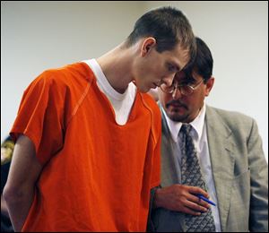 Corey S. Flugga, 22, consults with attorney Ken Sass during an extradition hearing in Findlay yesterday. 