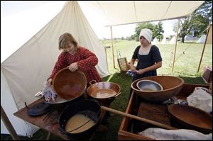 Katy Lemle of Monclova, left, and Kayla Utendorf of Elmore, Ohio, wash dishes the old-fashioned way after making corn bread.
