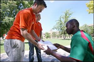 John Waynick, left, and Steve Zielaskiewicz ask BGSU student Emmanuel Tive to sign their petition, which seeks to change Bowling Green's occupancy law. Petition drive leaders say the city's present limit unfairly targets students. The group needs at least 805 signatures to get the initiative on the ballot.