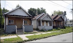 Houses at, from left, 930, 928, 926, and 924 Baker Street near Lagrange Street have boarded doors and windows.