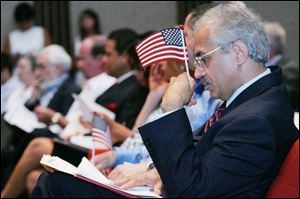 Former Iranian citizen Abdollah Aliakbarkha Afjeh reads some paperwork after becoming an American citizen yesterday.