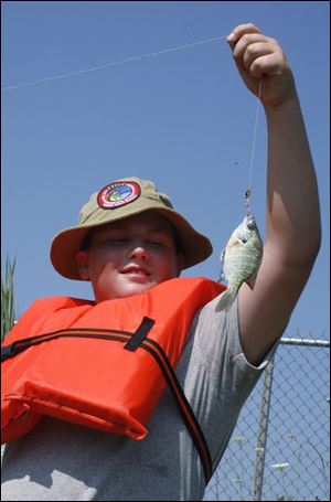 Nik Pinchoff, 11, of Monroe holds a fish he caught.