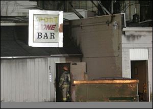 A firefighter looks inside the bar where fire caused extensive damage. The bar was not open last night. 