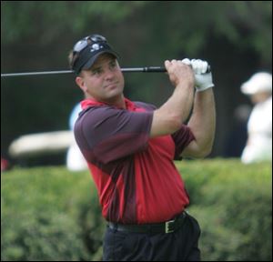 Jim Ozuk follows through on a shot at the Toledo District Golf Association s Stroke Play Championship at Stone Oak Country Club in Holland. After tying with Kevin Kornowa at 291 after 72 holes, Ozuk, 41, took the title by winning a playoff.