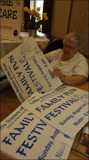 Volunteer Ray Hoak of Toledo gives each sign a wire mount that will hold it in place in someone's yard. 