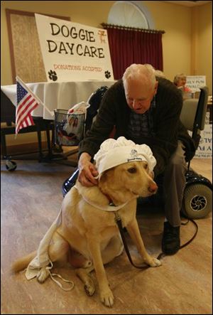 Sacred Heart resident Larry Hartman fits Sam with some headgear as he and other residents get ready for Sunday's festival. 