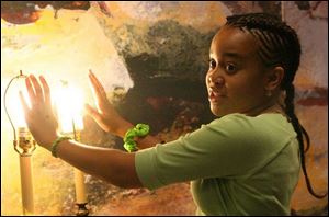 Waverly Hill-Mathis demonstrates the heat and light generation of incandescent and fluorescent light bulbs.