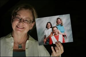 Melinda Swartz, 64, of Monclova Township, proudly shows off an 11-year-old photograph that shows herself, center; her daughter Sheila Swartz, then 13, left, and Stacy Dening, then 30, the daughter Ms. Swartz put up for adoption in 1967.