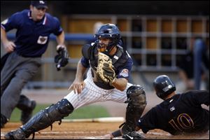 Max St-Pierre fields a throw, but it's too late to get Louisville's Luis Bolivar during the fifth inning at Fifth Third Field.