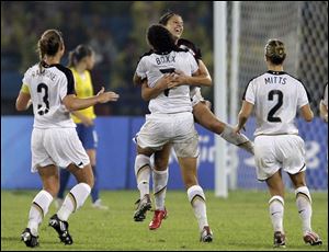 Shannon Boxx lifts Carli Lloyd as they celebrate Lloyd's goal in the sixth minute of extra time yesterday that gave the United States a 1-0 victory over Brazil in the gold medal game. The Americans had been in disarray heading into the Olympics.