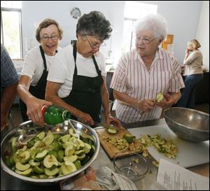 Shirley Hancock, left, Puffin Coe, and Jane Musgrave prepare salads for the free meals that are offered on the last Sunday of the month at St. Mark s Episcopal Church in the Old West End.