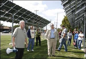 John Witte, left, explains the capabilities of the solar panel array at the University of Toledo's Wright Center for Photovoltaic Innovation and Commercialization.