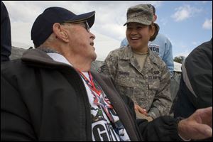 Therese Hazzard of Cincinnati helps her great-uncle Harold Johann with his gloves upon arriving at the World War II Memorial. Mr. Johann was inducted into the Army on his 30th birthday. 