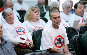 Jalal Kanan, in foreground, Paulette Sroczynski, left, and Lori Graczyk sport their message opposing a proposed auto salvage yard in South Toledo during the Toledo-Lucas County Plan Commission meeting. Steve Levetan of Pull-A-Part said they would strive to be good neighbors.