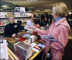 nbrn books13p 11/9/2008  blade photo by herral long   Tom Grace of Dexter mich  hands signed book to pat Costello of monroe  Writers on the river tenth annual  book fair at Ellis information center Monroe mich