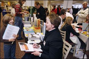 nbrn books13p 11/9/2008  blade photo by herral long   Hannah Pifer 9 of jefferson elem - monroe  with   author Cynthia Furlong Reynolds  of  Dextrer mich   Writers on the river tenth annual  book fair at Ellis information center Monroe mich