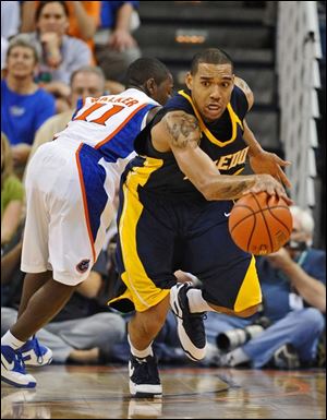 Toledo's Jonathan Amos starts up court with the ball after a steal from Florida's Erving Walker (11) during the second half of the game in Gainesville. UT lost 80-58.