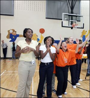 Leverette Middle School students, including seventh-graders Latesha Craig, 13, Cierra Moran, 12, and Mahalia Middlebrooks, 13, from left, cheer on their teammates as they race to the finish line during the kickoff in the gym yesterday.