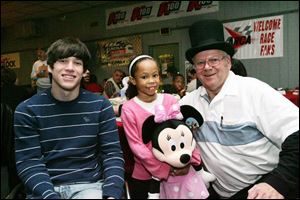 Brandon Lillibridge of West Toledo, left, and Tionne Vandevelde of Toledo, clutching Minnie Mouse, were helped by the Pacers Car, of which Jim Intagliata, right, is president.