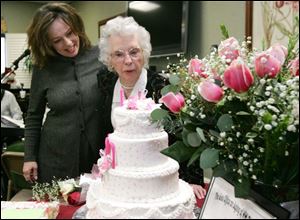 Emma Parker blows out the candles on a cake for her 100th birthday. With her is granddaughter Lisa Paxton of Lambertville.