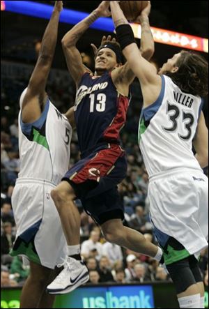 The Cavaliers  Delonte West, who scored 21 points, splits Minnesota defenders Craig Smith, left, and Mike Miller.