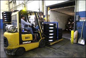 A worker moves tires to a trailer at the Cooper plant in Findlay.