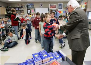 Ryan Harrison is all smiles as Rotarian Dave Lindsey hands him his own thesaurus and dictionary.