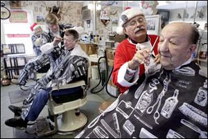 Gilbert Kosa, 92, who has come to Gus Janssens' shop for haircuts for three or four years, says the Santa suit adds some holiday panache.