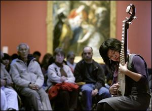 Slug:  CTY chinese05p Date:  01042009        The Blade/Andy Morrison       Location:  Toledo       Caption: Yitong Jiang from the University of Toledo, performs a PiPa solo during the Chinese Association of Greater Toledo's 2009 Winter Legacies Program at the Toledo Museum of Art, Sunday, 01042009.    Summary: