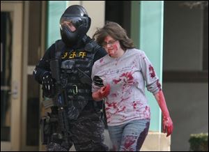 An Ohio Highway Patrol SWAT team member escorts a 'victim' from Olscamp Hall, the site of a mock shooting at BGSU. 