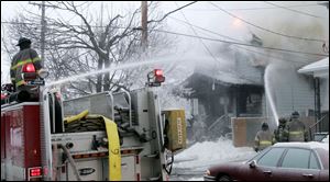 Firefighters direct water onto the burning White Street home Wednesday morning. 