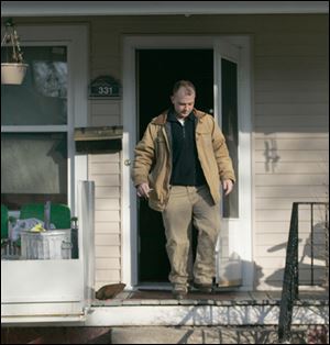 An investigator from the coroner's office exits the home at 331 Austin in North Toledo, where resident Charline Spearman died last night.