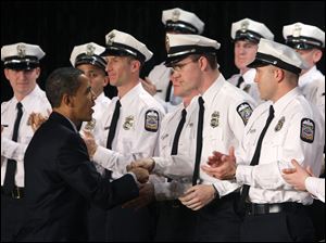 President Obama congratulates police recruits during their graduation ceremony in Columbus. The new officers faced layoffs until funds from the economic stimulus plan arrived.