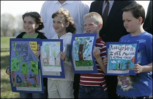 NBRS woodland29p  04/24/09  The Blade/Dave Zapotosky Caption: L-R- Moira Sams, 10, fifth grade, Natalie Ondrus 8, second grade, Jack Ryder, 7, first grade, and Lucas Rickman, 9, 3rd grade, all students at Fort Meigs School who won awards for posters they created, pose for pictures during the  25th anniversary Arbor Day celebration in Woodlands Park in Perrysburg, Ohio, Friday, April 24, 2009. There were winners from every grade level at Woodland, Toth, Fort Meigs, Frank, and St. Rose schools. Summary: 25th anniversary Arbor Day  celebration at Woodlands Park Shelter House in Perrysburg.