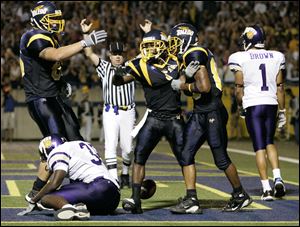 Teammates help Rockets receiver Andrew Hawkins, center, celebrate his touchdown reception against Western Illinois in 2005 in the Glass Bowl. Hawkins was a jack of all trades for Toledo.